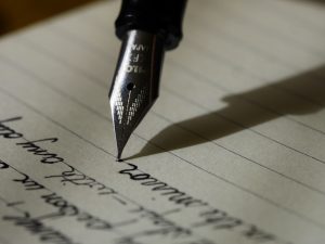 Närbild på en penna och anteckningsblock